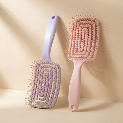 Plastic hairbrush with a large curved shape and hollow ribbed design
